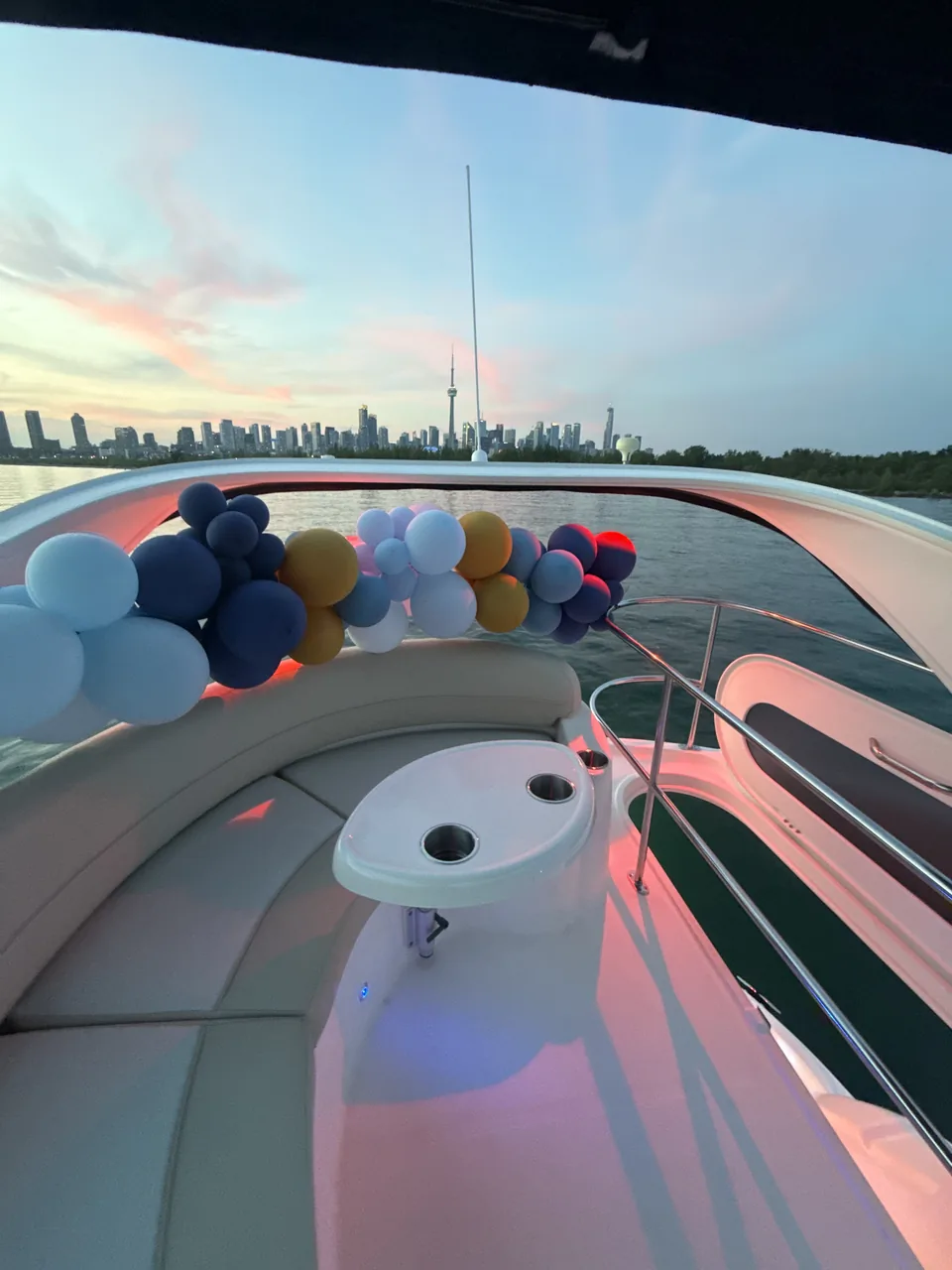 A balloon arch on the bow at dusk, the skyline beyond.