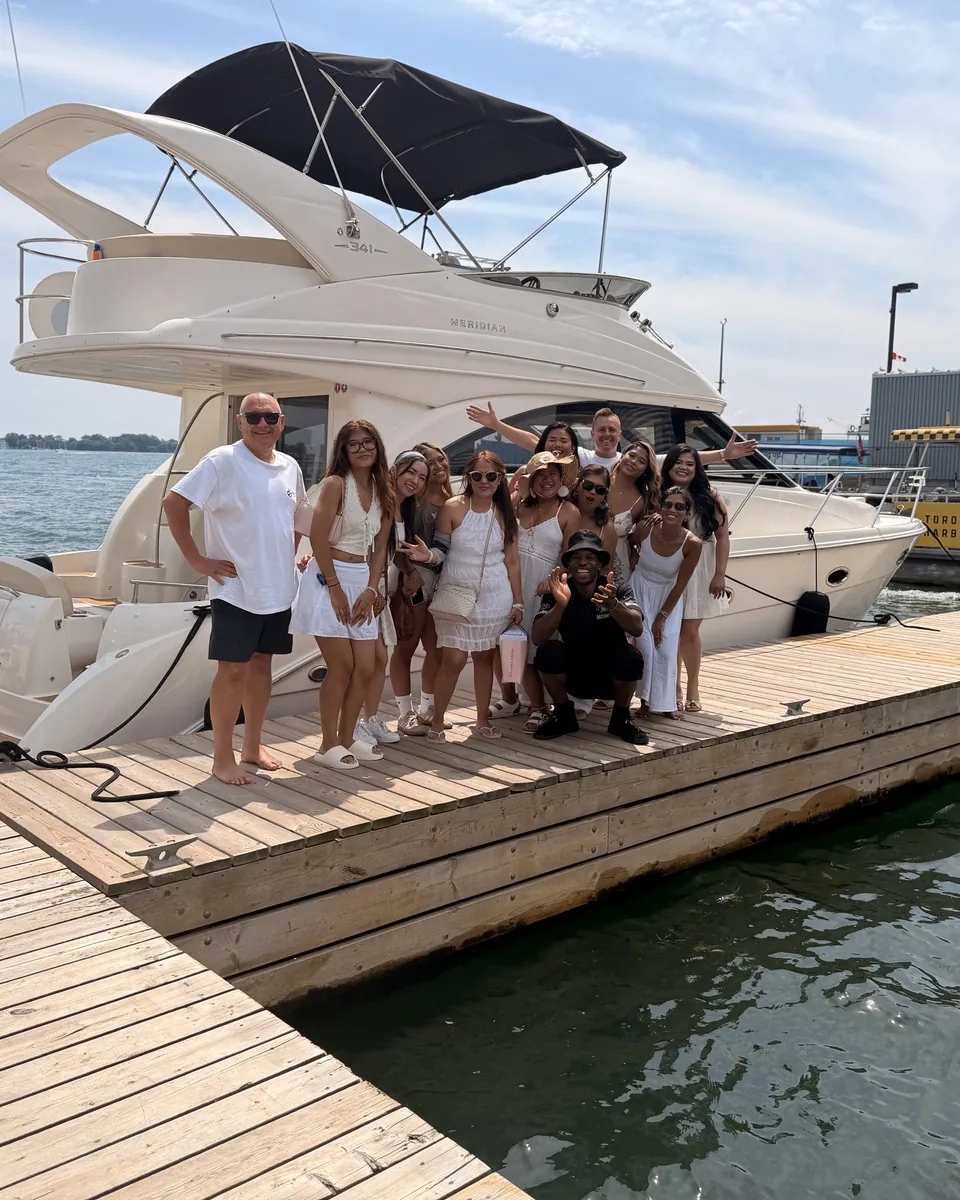 Guests gathered on the dock beside the yacht before boarding.
